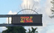 A variable-message sign over a road that reads 'Pokémon Go is a no-go when driving'.